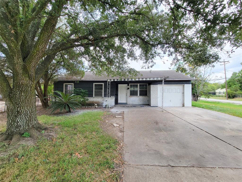 front view of a house with a yard and an trees