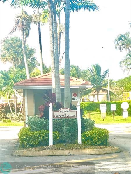 a view of a house with a yard and palm trees