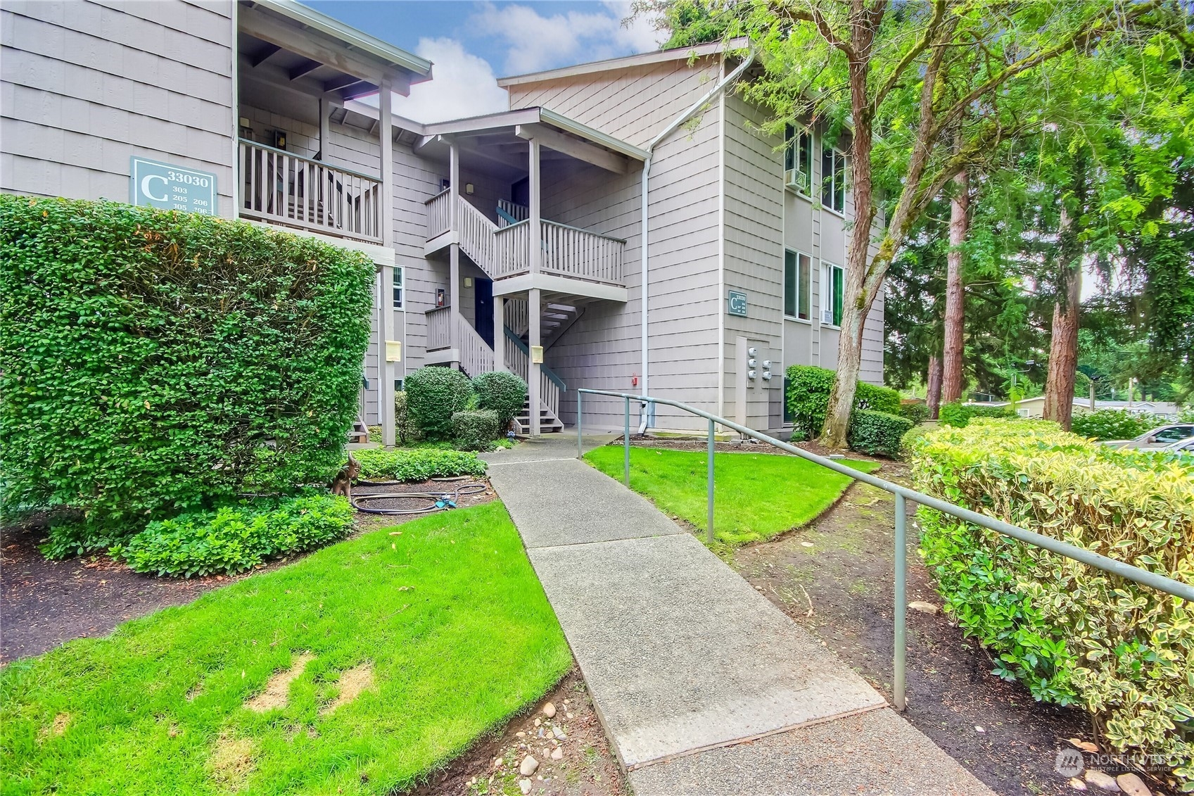 a view of a house with a yard and potted plants