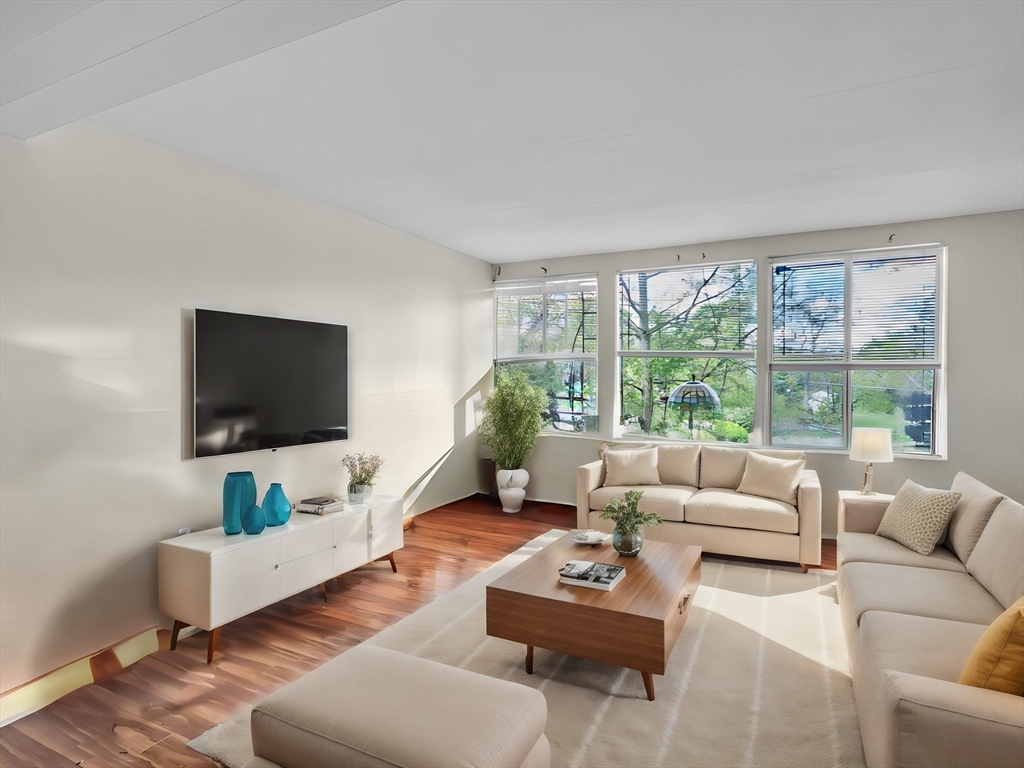 a living room with furniture flat screen tv and a large window