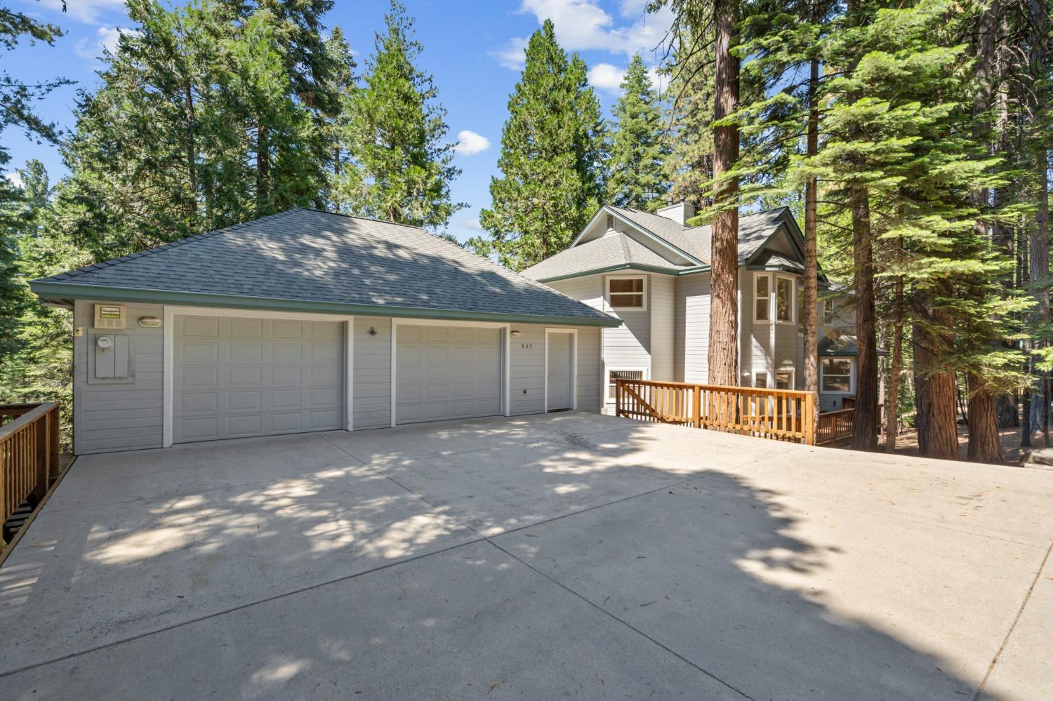 a view of a house with a yard and large tree