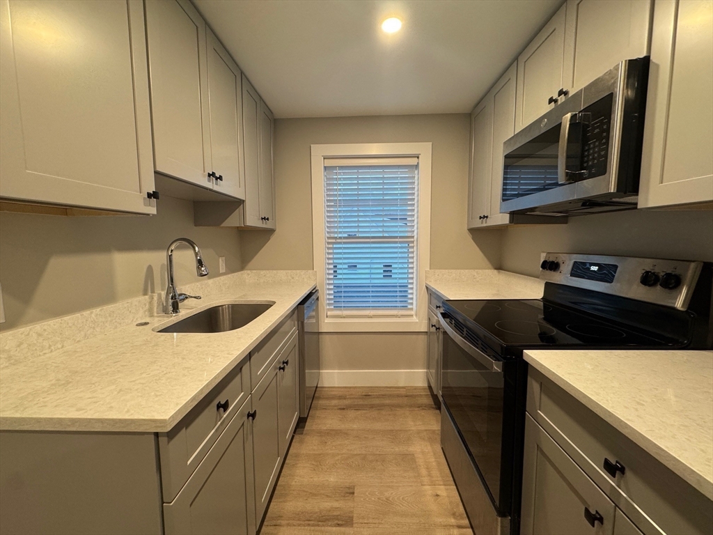 a kitchen with stainless steel appliances granite countertop a sink and a stove