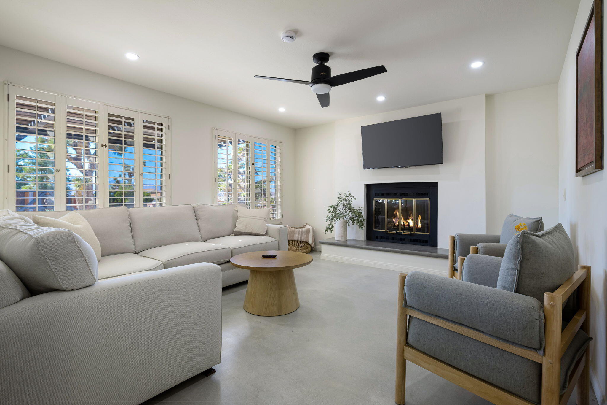 a living room with furniture a fireplace and a flat screen tv