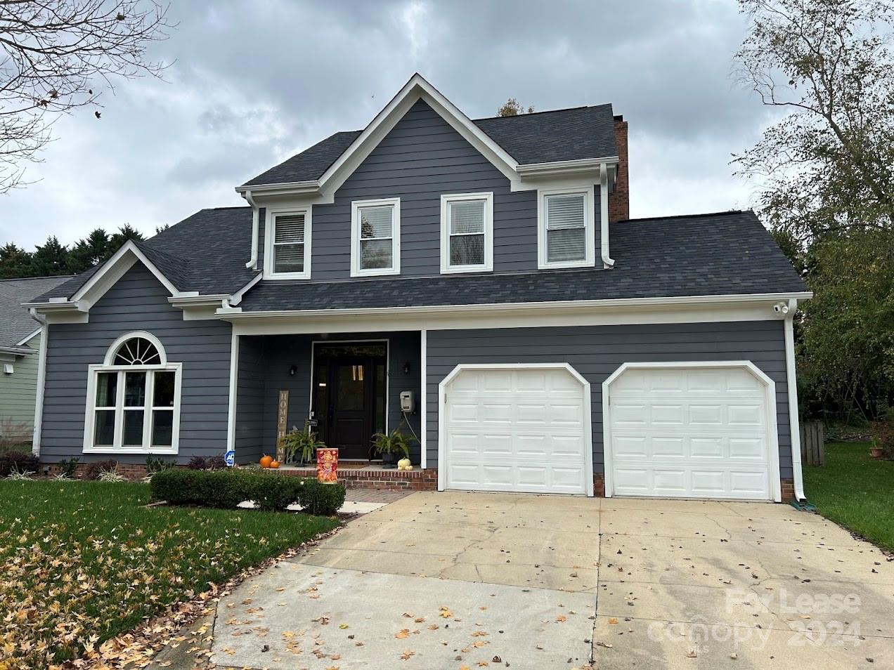 a front view of a house with a garden and garage