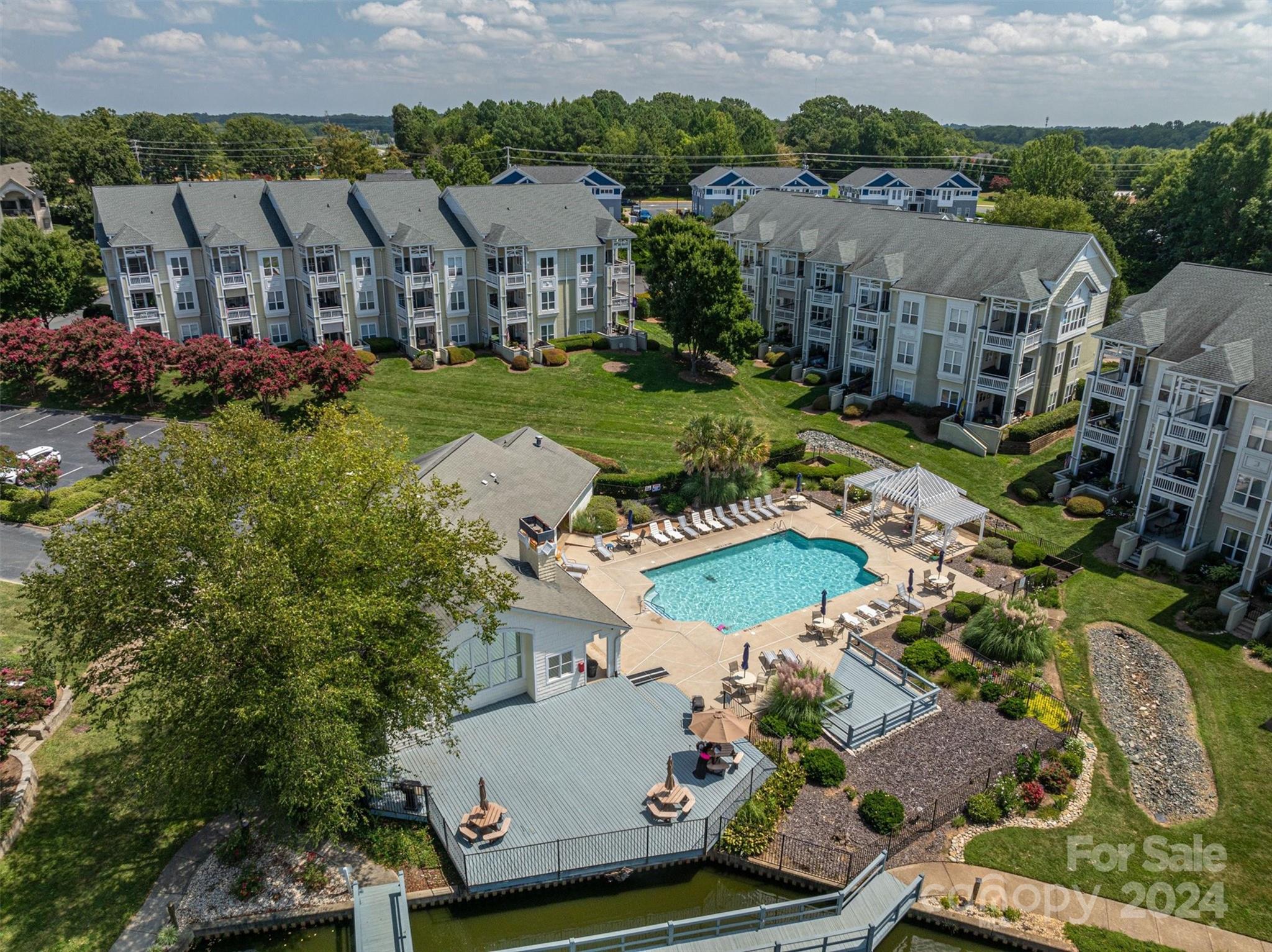 an aerial view of residential houses with outdoor space and parking