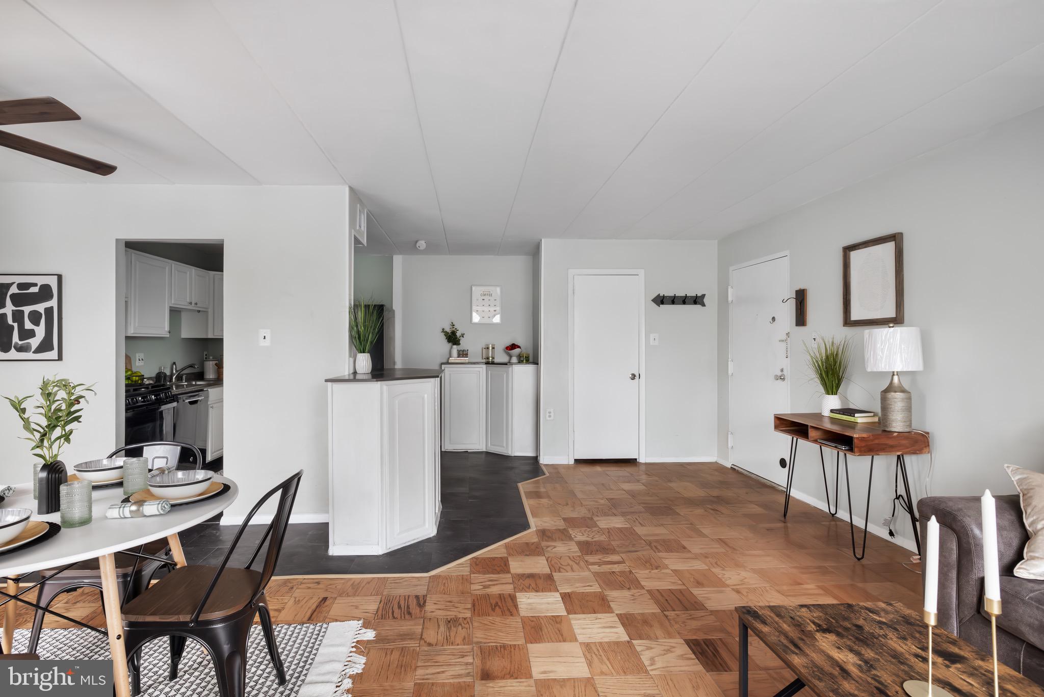 a living room with furniture a dining table and a refrigerator