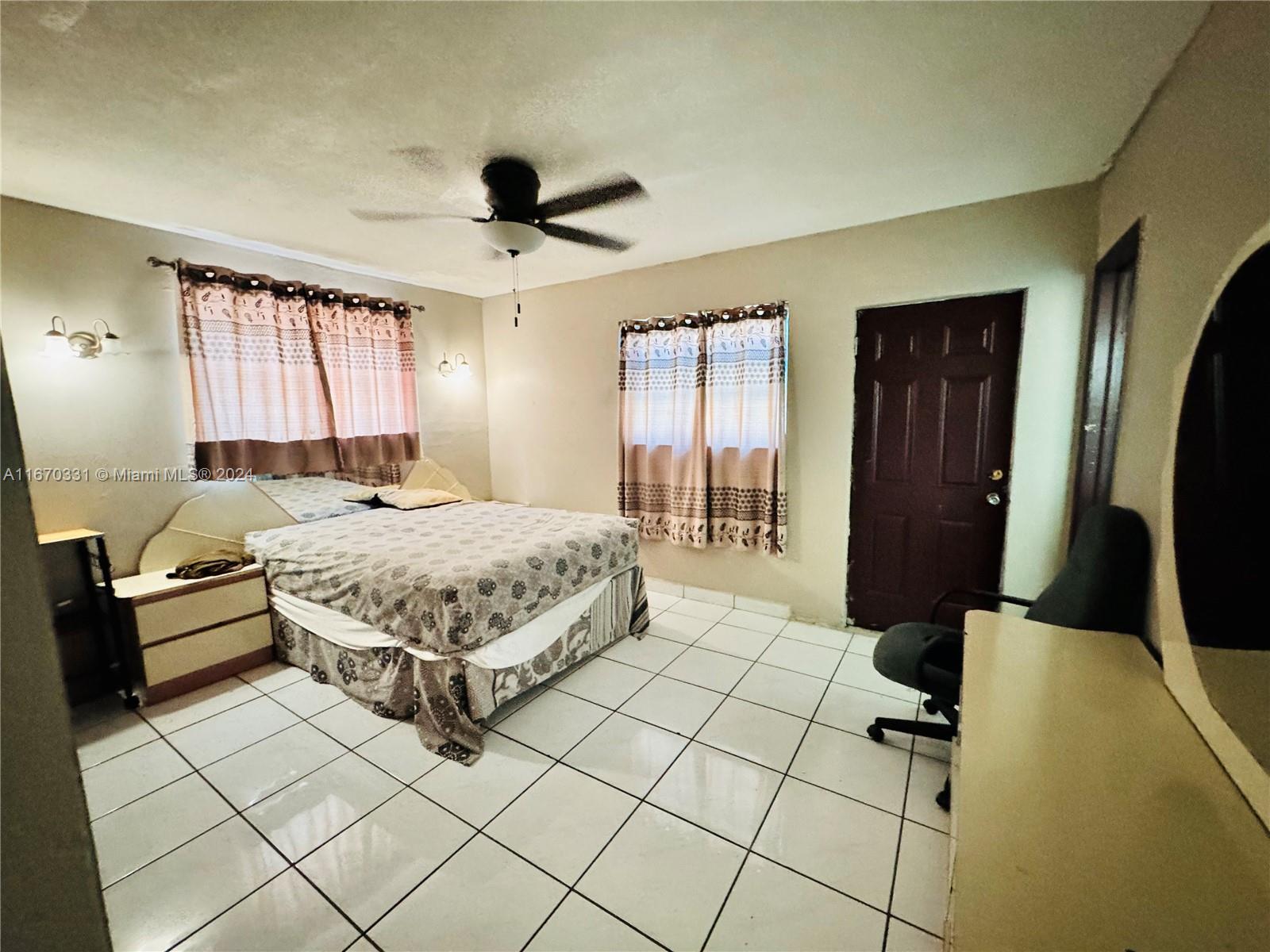 a bedroom with a bed mirror and window