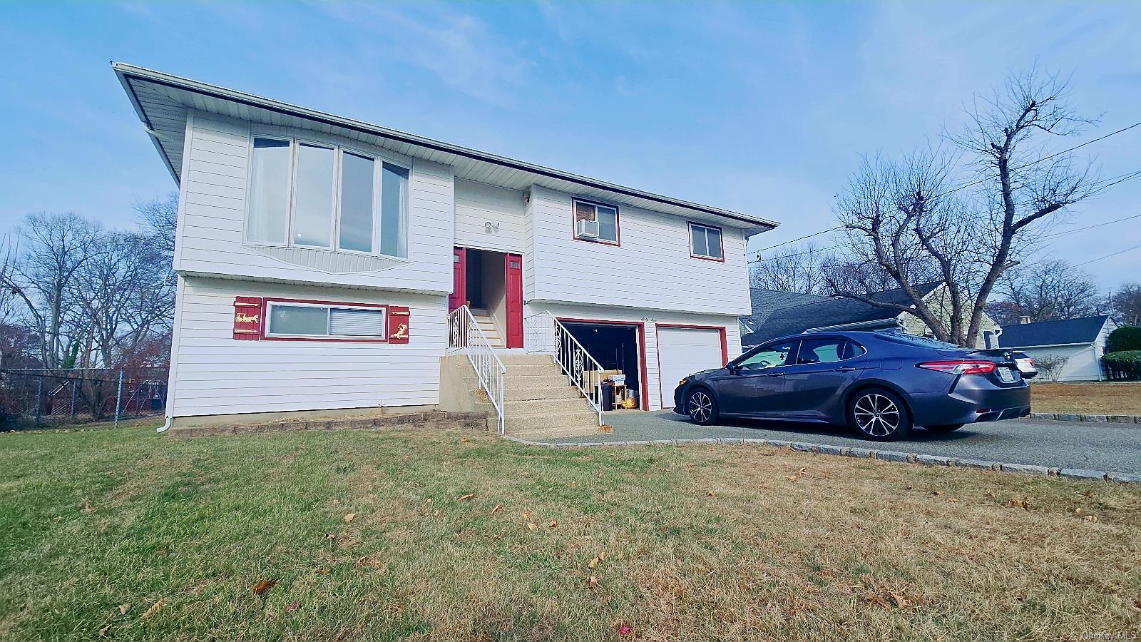 Bi-level home with a garage and a front lawn