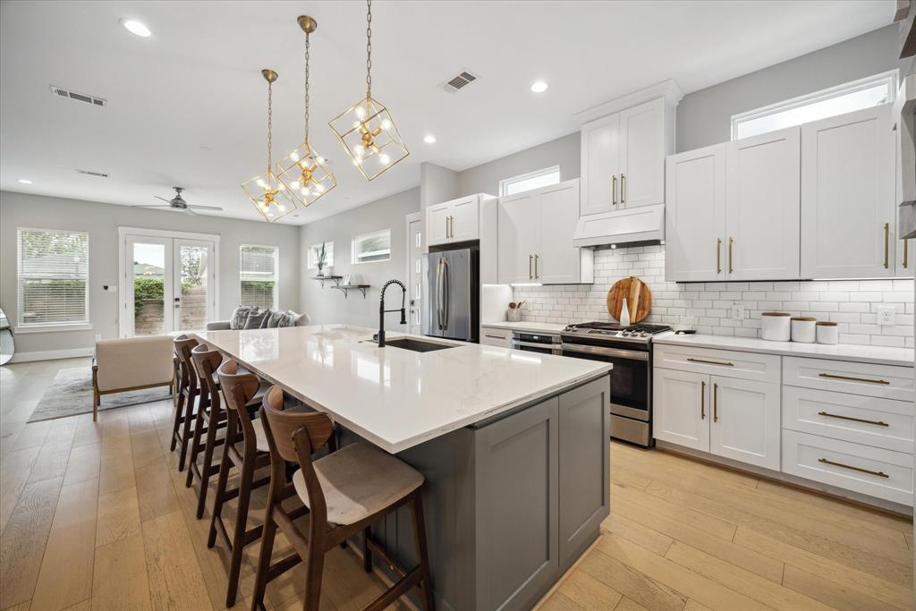 a kitchen with a dining table chairs stainless steel appliances and cabinets