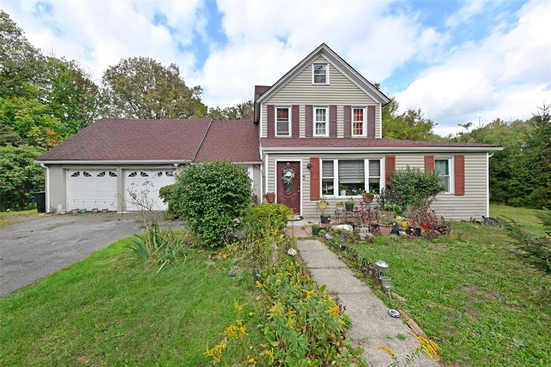 View of front property with a porch, a garage, and a front lawn