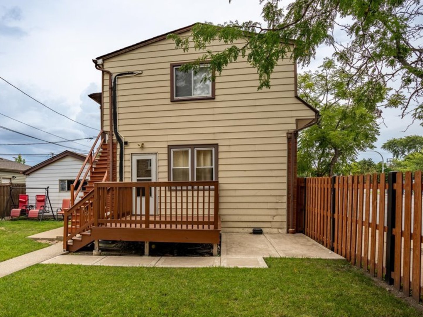 a view of a house with a yard and deck area with a garden