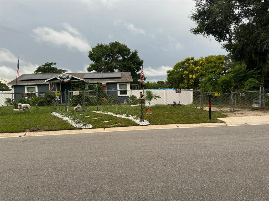 a view of a house with a yard and palm trees