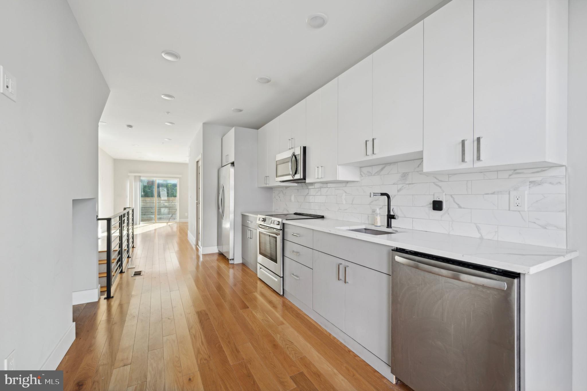 a kitchen with stainless steel appliances sink stove top oven and cabinets