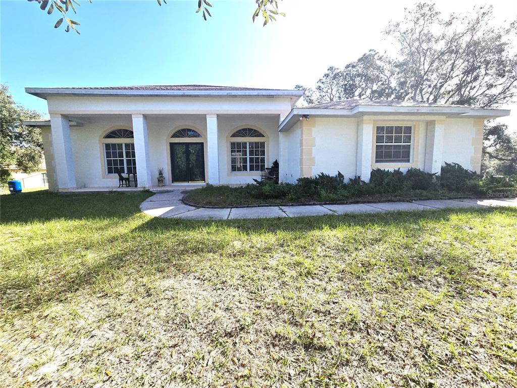 a view of a house with swimming pool and a yard