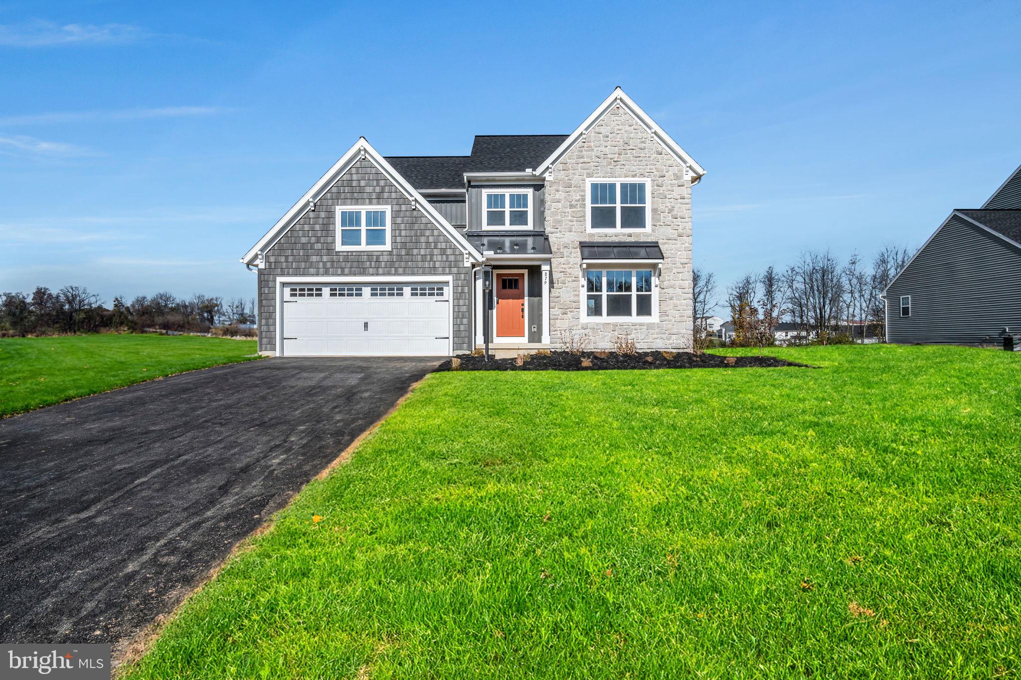 a front view of a house with a yard and trees