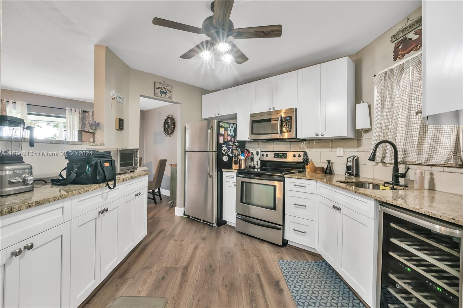 a kitchen with white cabinets and appliances