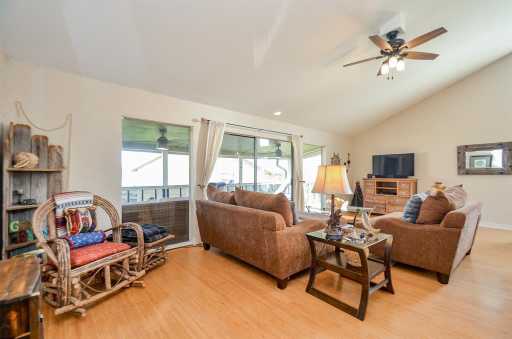 a living room with furniture a flat screen tv and a large window