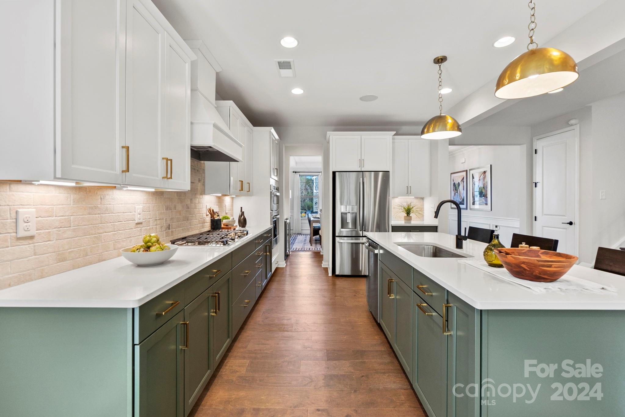 a large kitchen with stainless steel appliances lots of counter space and a sink