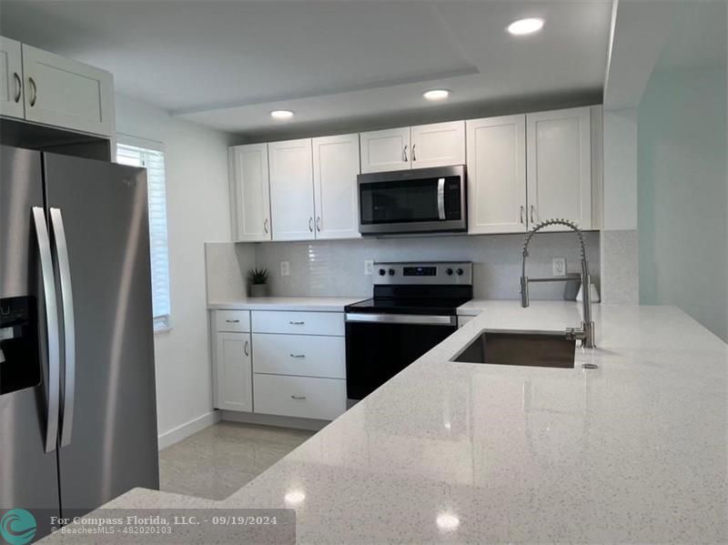 a kitchen with stainless steel appliances a refrigerator stove microwave and cabinets