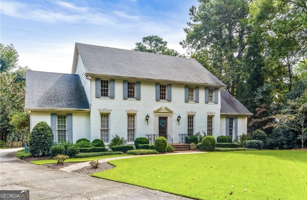 a front view of a house with yard and green space