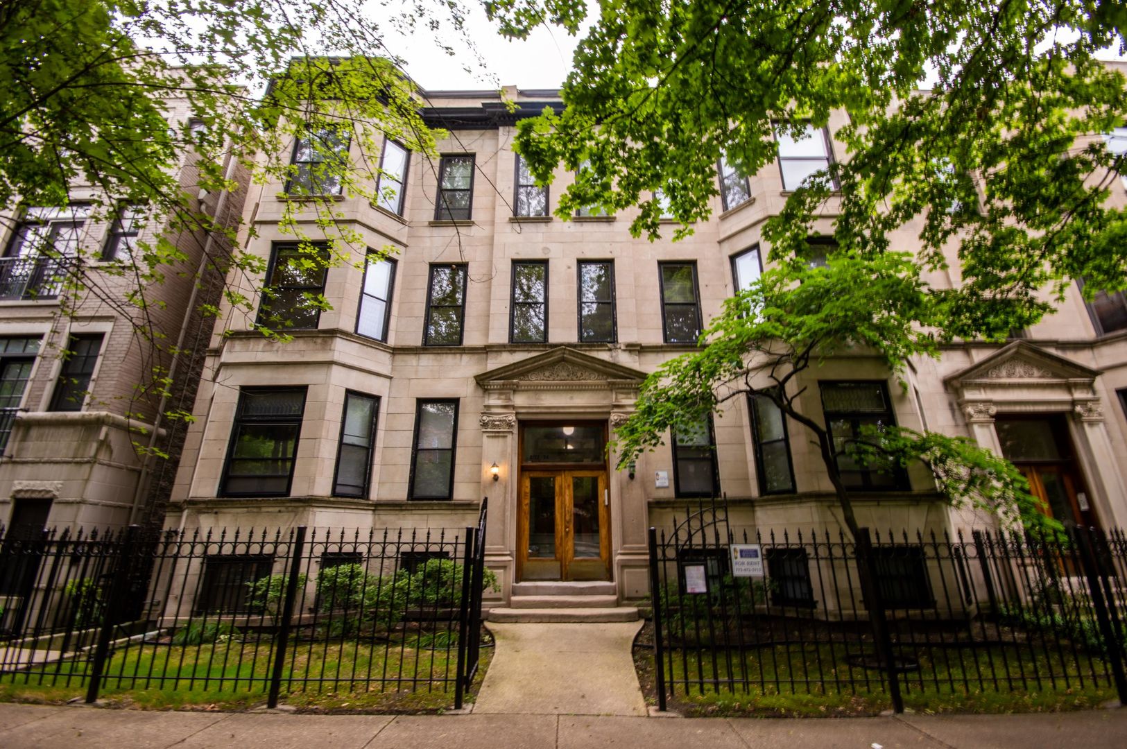 a front view of a residential apartment building with a yard