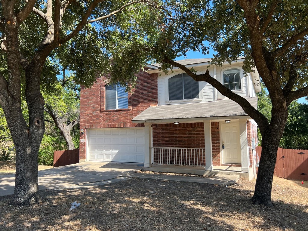 a front view of a house with a tree