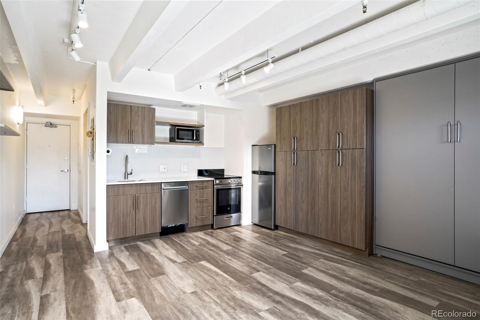 a kitchen with a refrigerator and a stove top oven