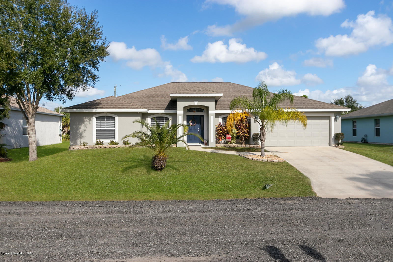 a front view of a house with a garden and yard