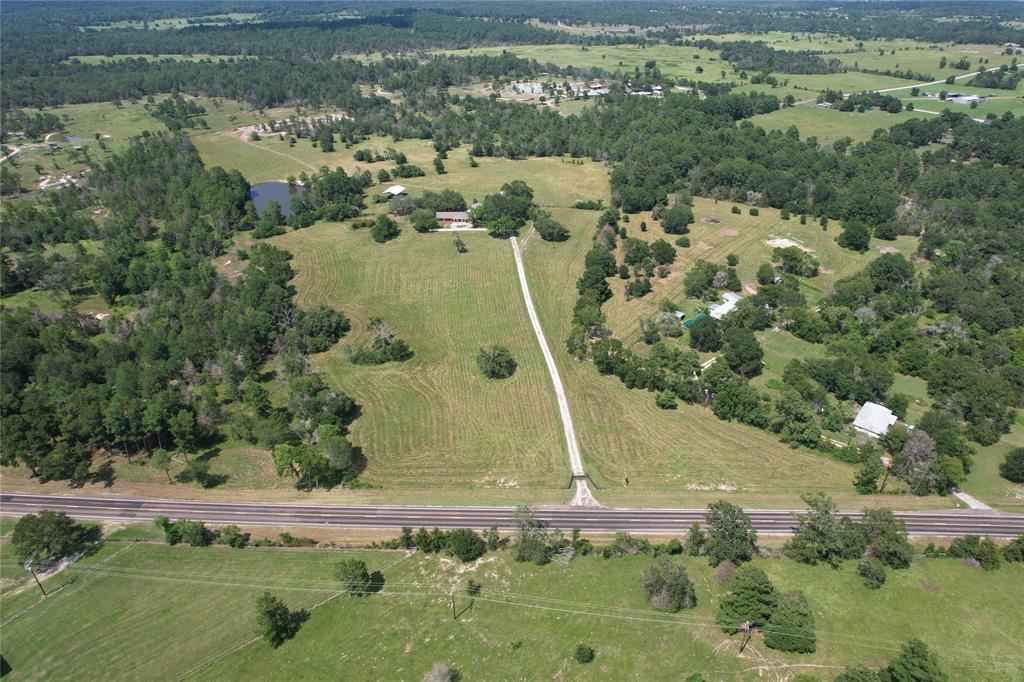 an aerial view of residential houses with outdoor space and trees