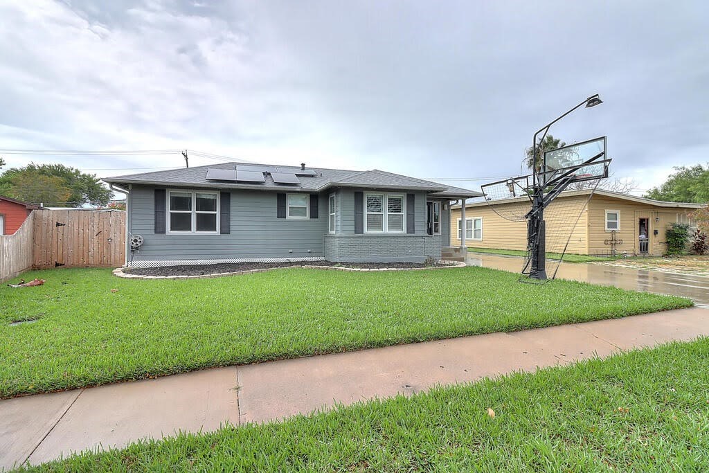 a front view of a house with a garden and yard