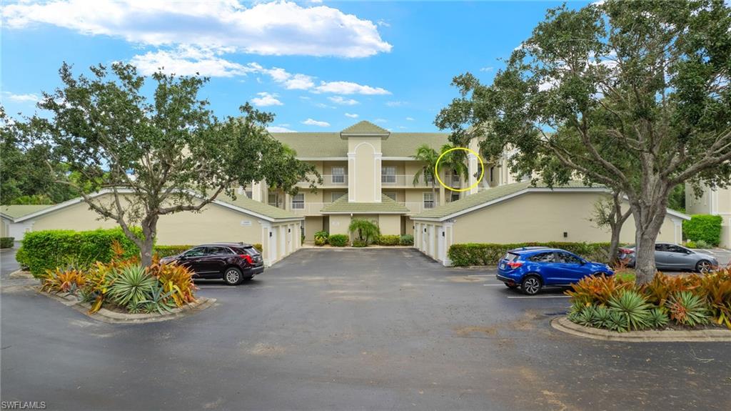 View of building exterior with garages and guset parking