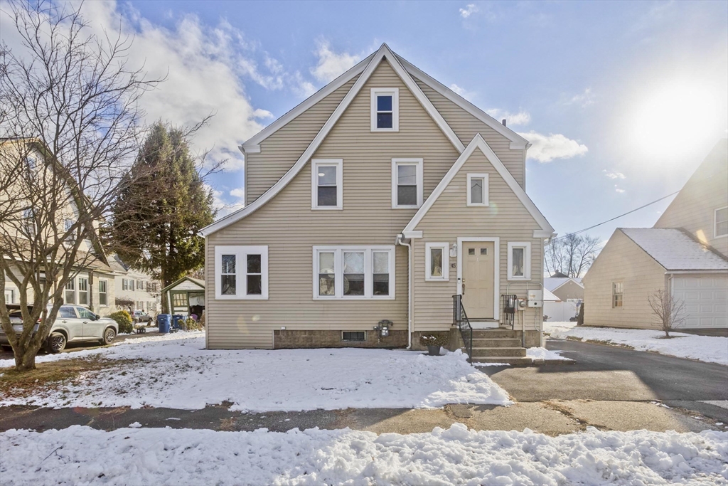 a front view of a house with a yard covered in snow