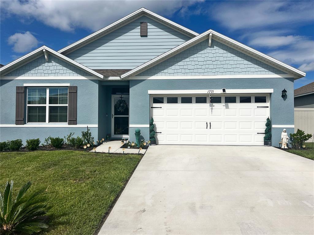 Front exterior with garage door opener, upgraded exterior, storm door