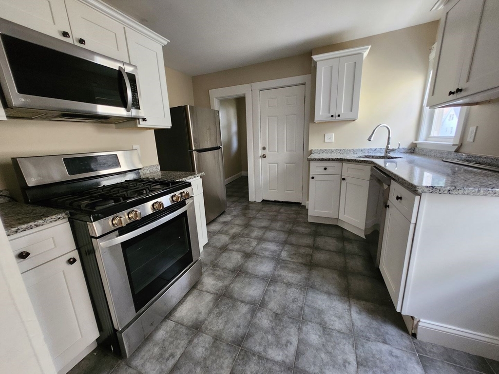 a kitchen with sink stainless steel appliances and cabinets