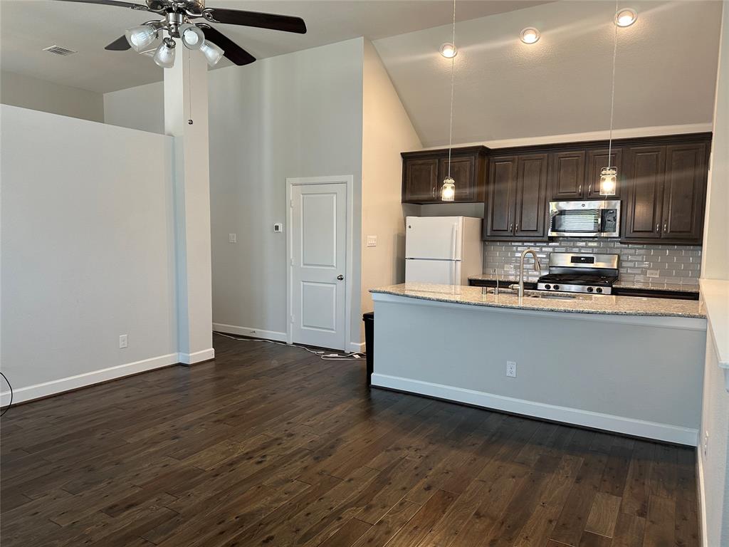 a kitchen with stainless steel appliances a refrigerator and a stove top oven