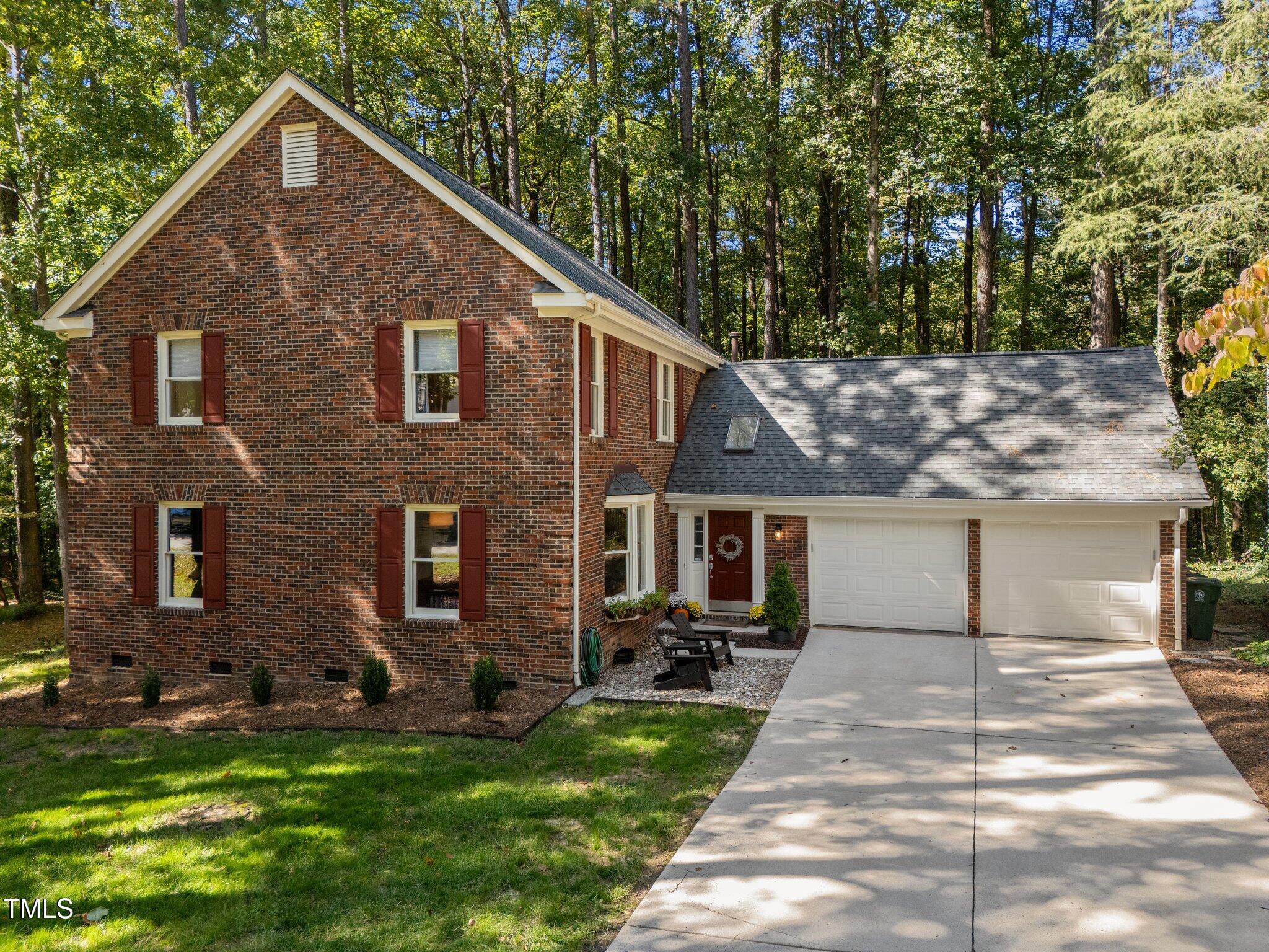 a view of a yard in front of a brick house with plants