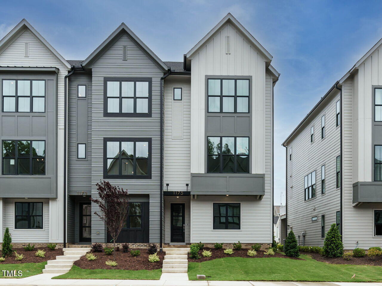 a front view of a residential apartment building with yard and windows