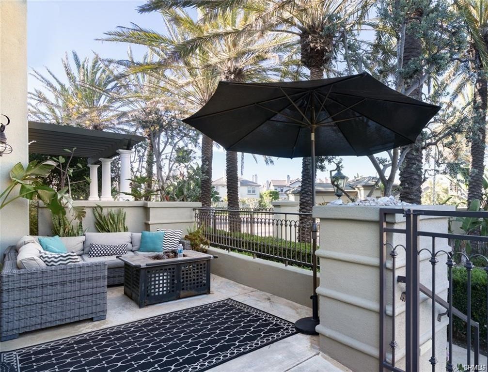 a view of a patio with couches table and chairs under an umbrella