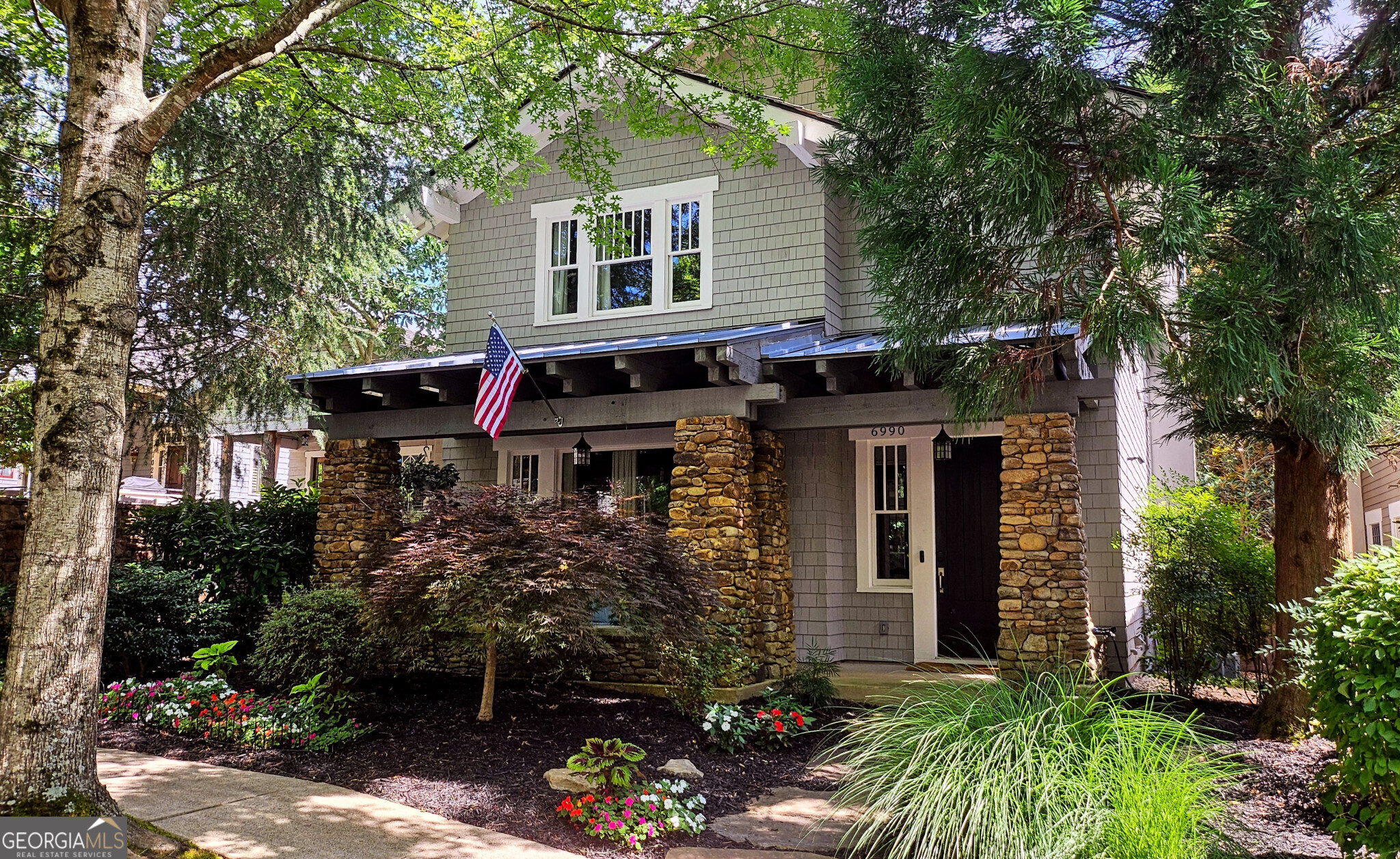 a view of a house with brick walls and a flower garden