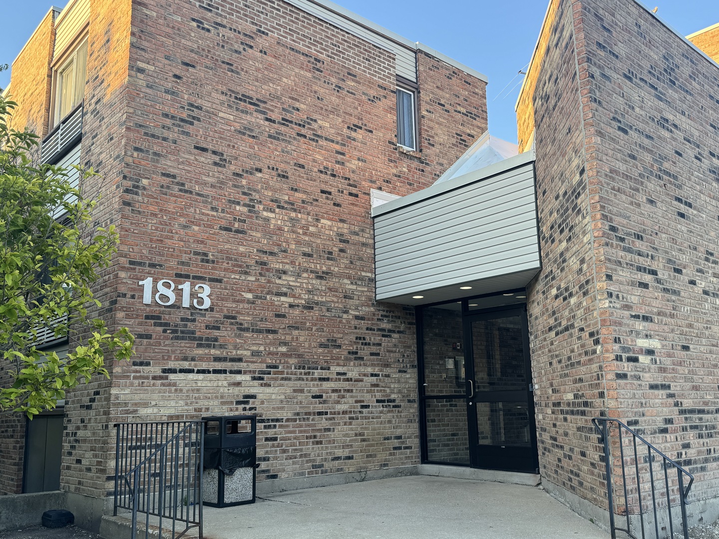 a brick building with a bench and a potted plant