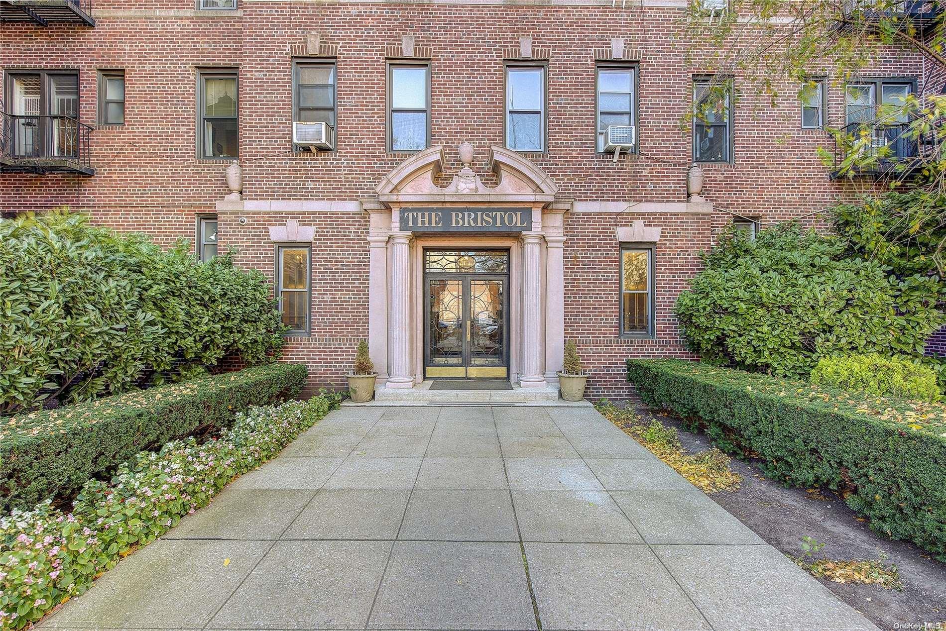 a front view of a building with a garden