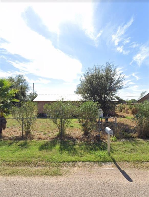 a view of a yard with flower plants and wooden fence