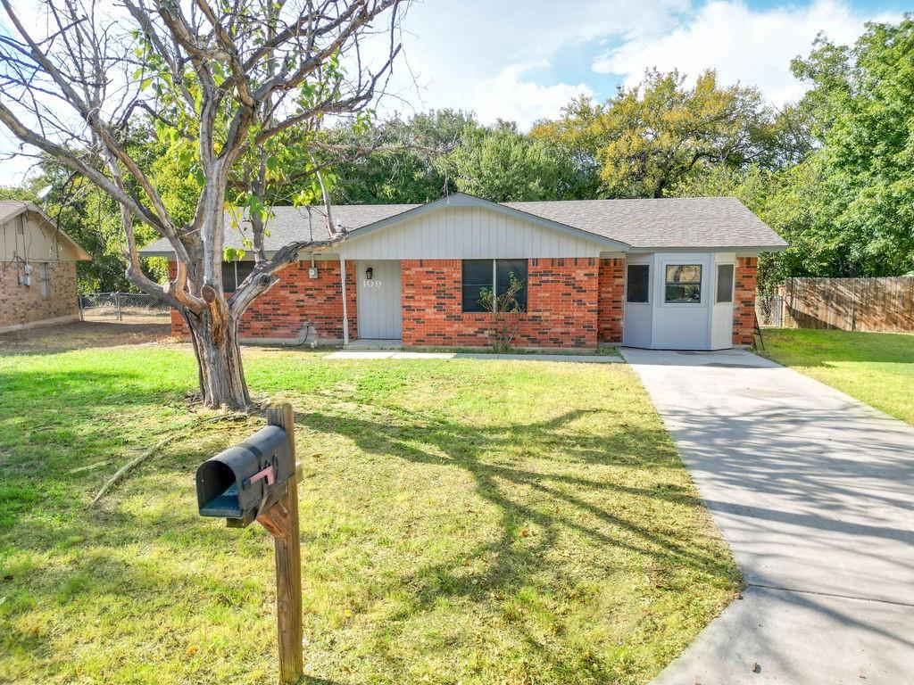 a front view of a house with yard and green space