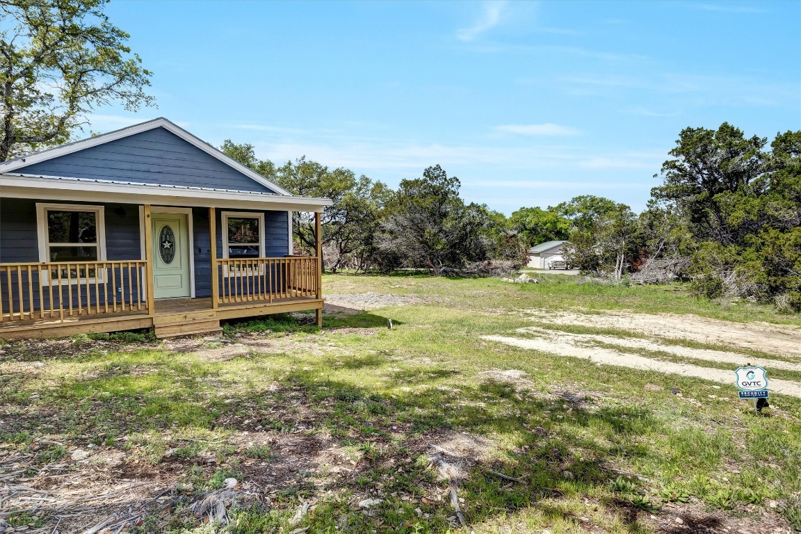 a view of a house with backyard and a tree