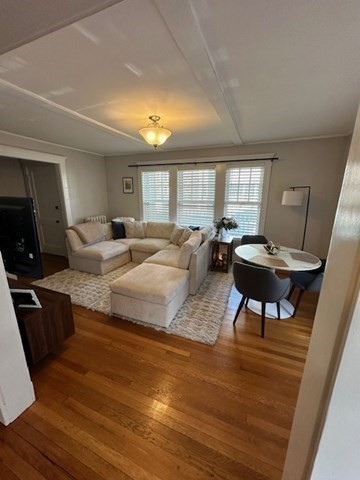 a living room with furniture a window and a wooden floor