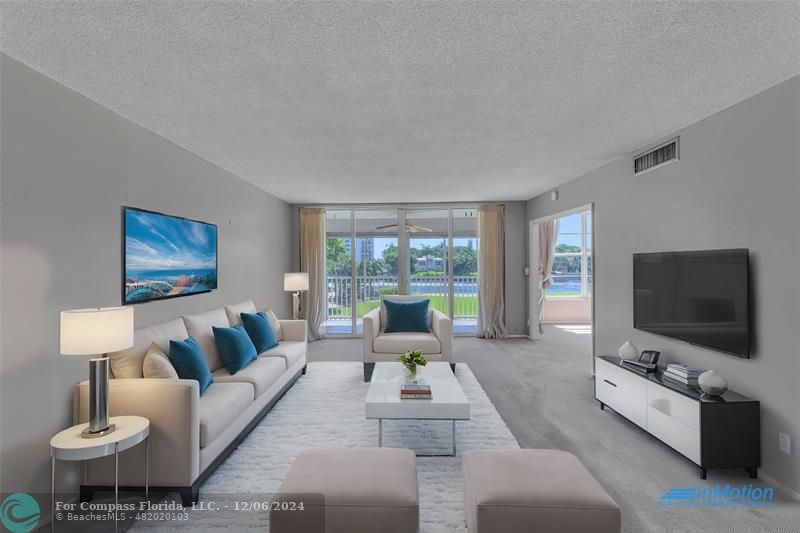 Large and spacious living room with amazing water views of main intracoastal and sliders to screened patio - staged photo