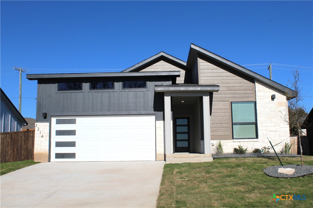 a view of a house with a garage and yard