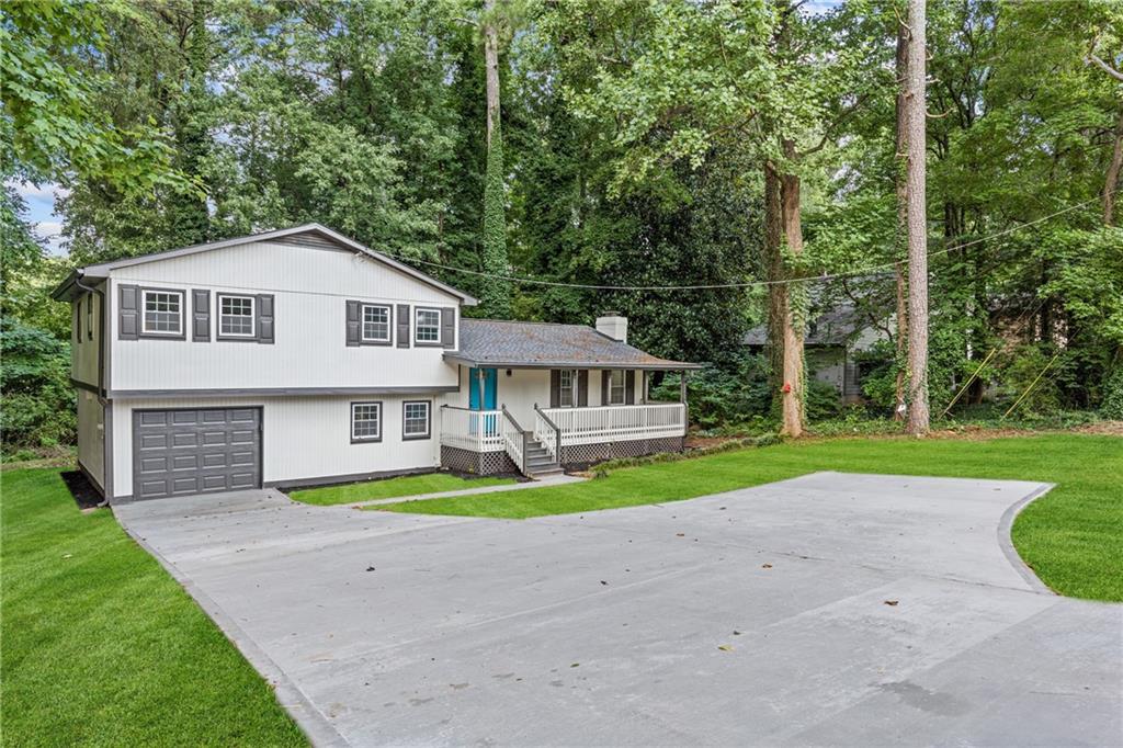 a view of a house with a yard and sitting area