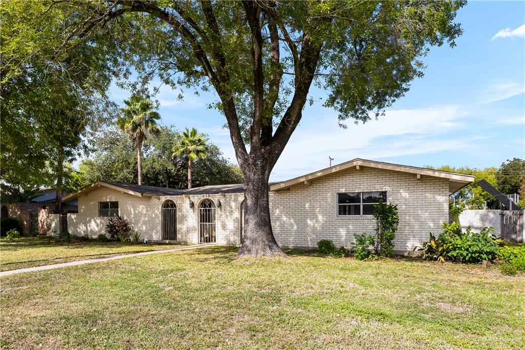 a front view of house with yard and trees around