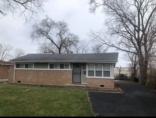 a front view of a house with a garden and yard